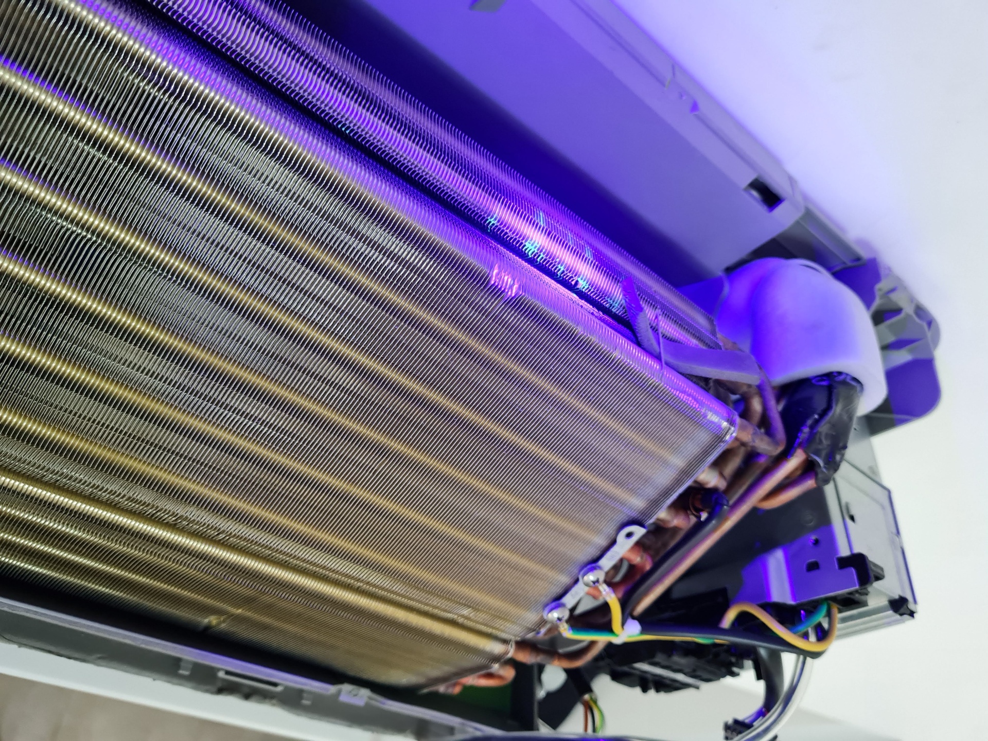 Gros plan — fuite révélée à la lampe UV sur l'évaporateur